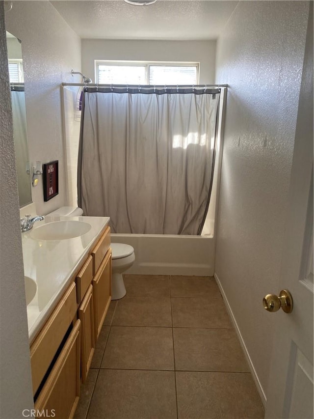 full bathroom featuring shower / tub combo with curtain, toilet, a sink, a textured ceiling, and tile patterned flooring