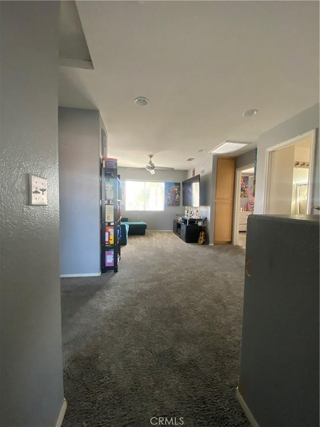 corridor featuring baseboards and carpet floors