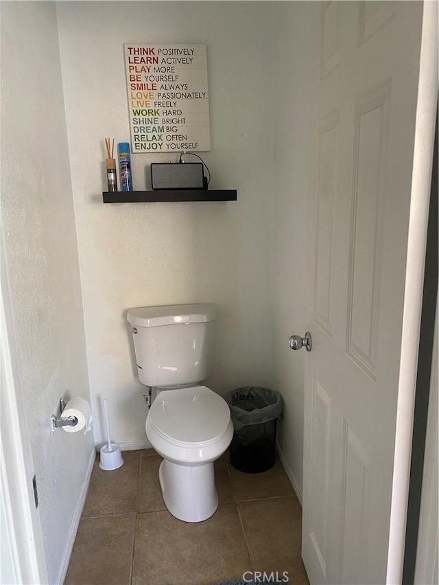 bathroom featuring tile patterned flooring, toilet, and baseboards