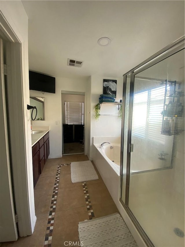 full bath featuring tile patterned floors, visible vents, a garden tub, a stall shower, and vanity