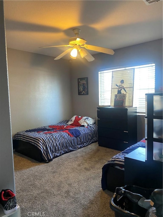 bedroom featuring visible vents, ceiling fan, and carpet flooring