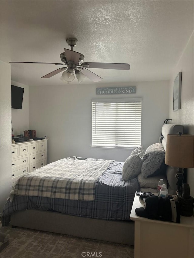 bedroom featuring a textured ceiling and a ceiling fan