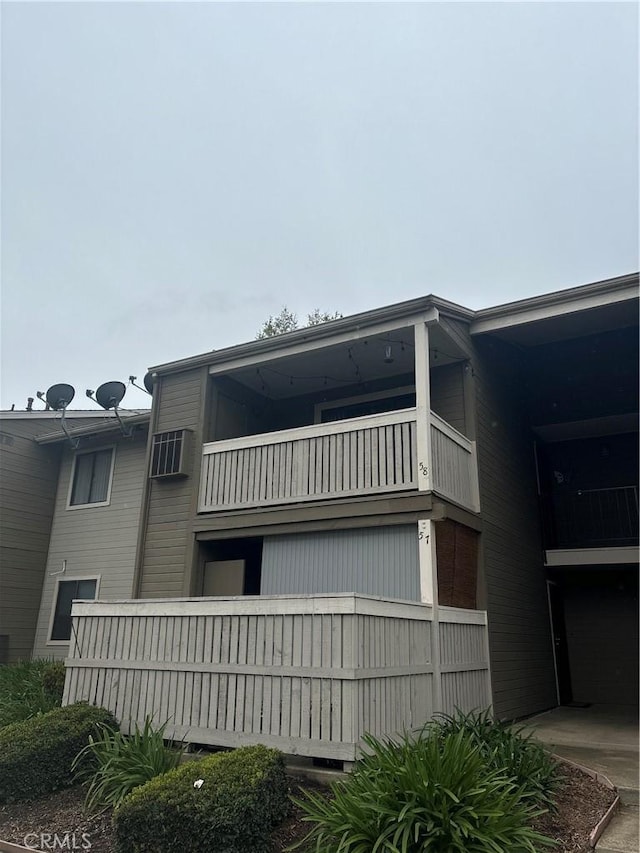 view of property exterior featuring a balcony and a wall mounted AC