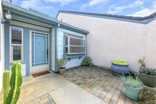 property entrance featuring stucco siding and a patio