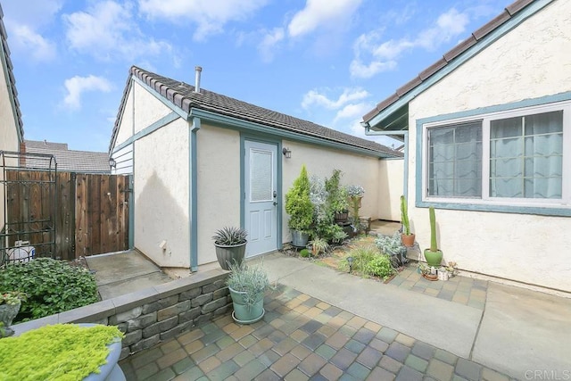 exterior space featuring a patio, fence, and stucco siding