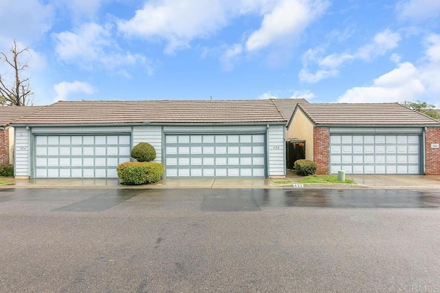 ranch-style home featuring community garages and a tile roof