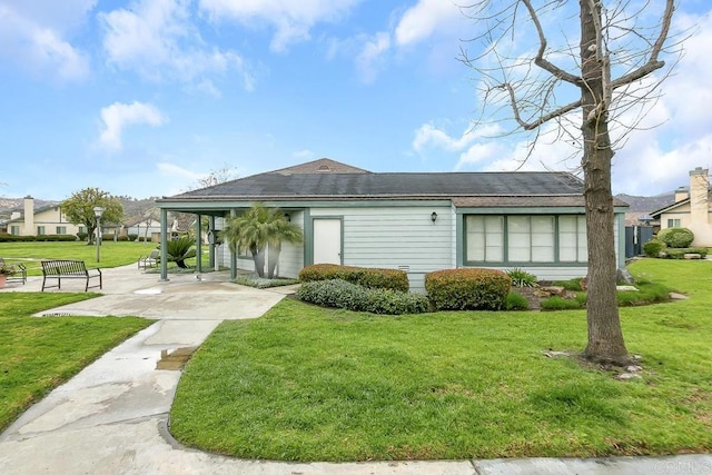 rear view of property featuring a yard and a shingled roof