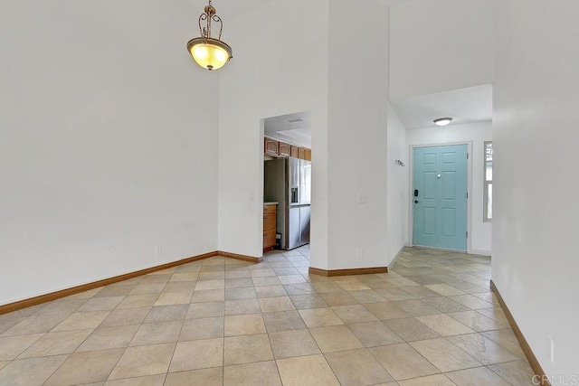 empty room with baseboards and a high ceiling