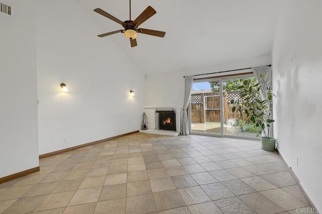 unfurnished living room featuring baseboards, a brick fireplace, high vaulted ceiling, and a ceiling fan