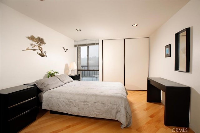 bedroom with floor to ceiling windows, recessed lighting, light wood-style flooring, and a closet