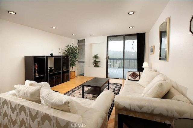 living area featuring recessed lighting, light wood-style floors, and expansive windows