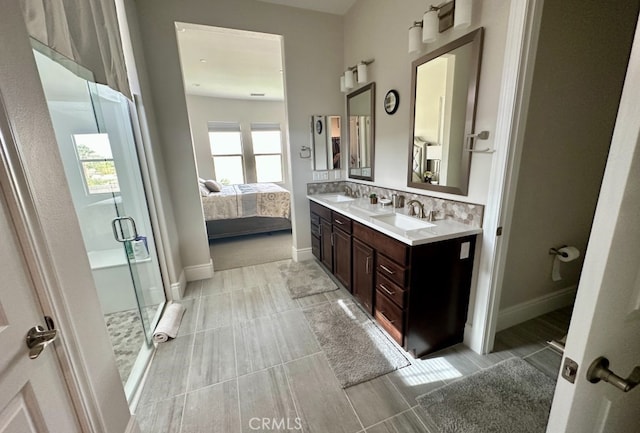 full bath featuring a stall shower, a sink, tasteful backsplash, ensuite bath, and double vanity