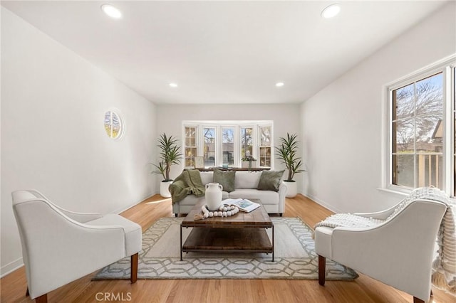 living area with recessed lighting, baseboards, and wood finished floors