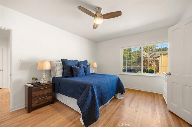 bedroom with ceiling fan, light wood-type flooring, and baseboards