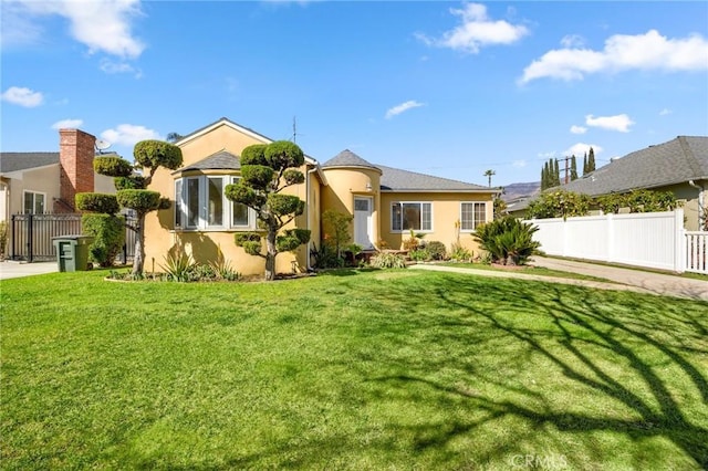 single story home with a front lawn, fence, and stucco siding