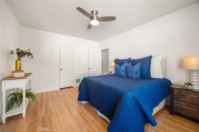 bedroom with baseboards, a ceiling fan, and light wood finished floors