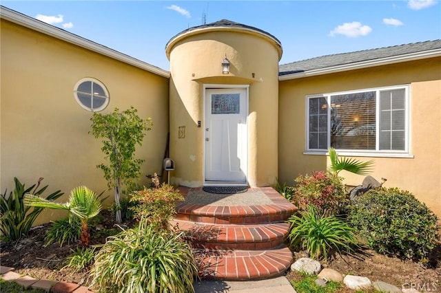 entrance to property featuring stucco siding