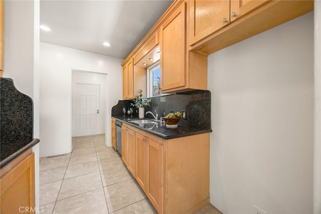 kitchen with dark stone countertops, light tile patterned floors, a sink, dishwasher, and tasteful backsplash