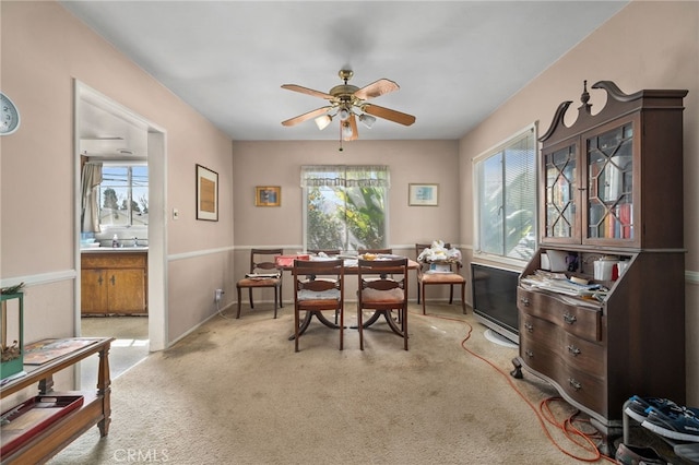 dining room featuring light colored carpet and a ceiling fan