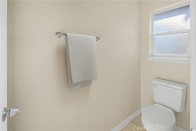 bathroom with tile patterned flooring, toilet, and baseboards