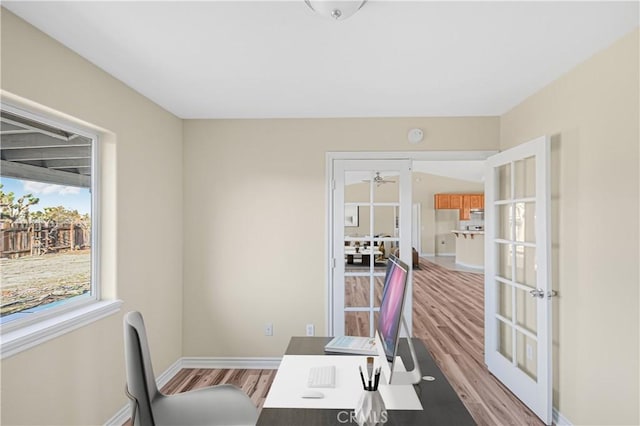 office space featuring light wood-style flooring, french doors, and baseboards