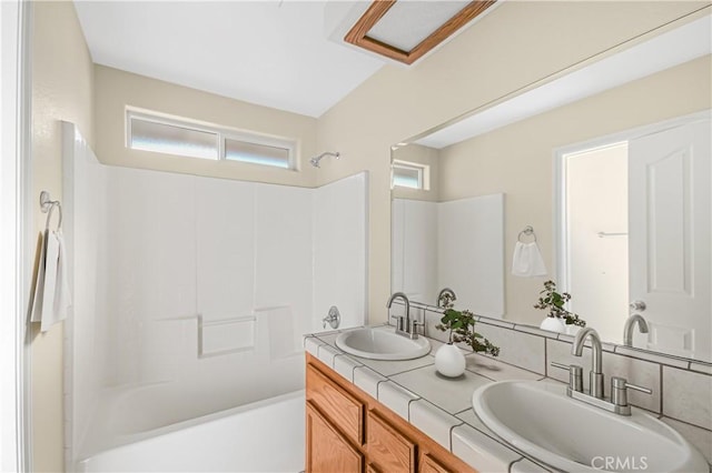 full bath with double vanity, tub / shower combination, and a sink