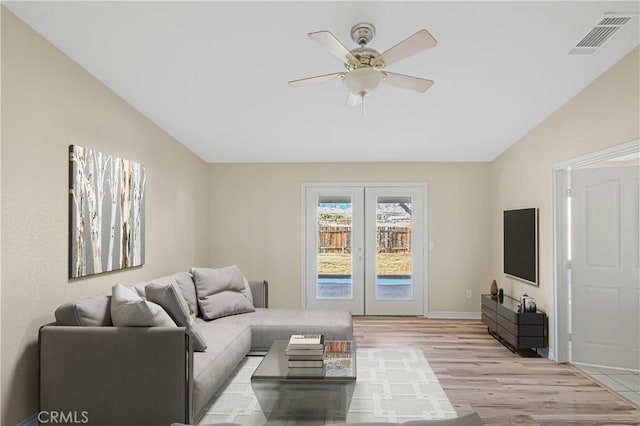 living area with visible vents, french doors, light wood finished floors, lofted ceiling, and ceiling fan