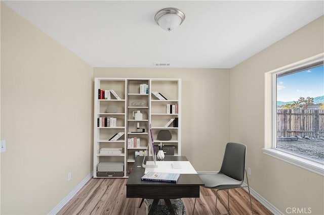 office with visible vents, baseboards, and wood finished floors