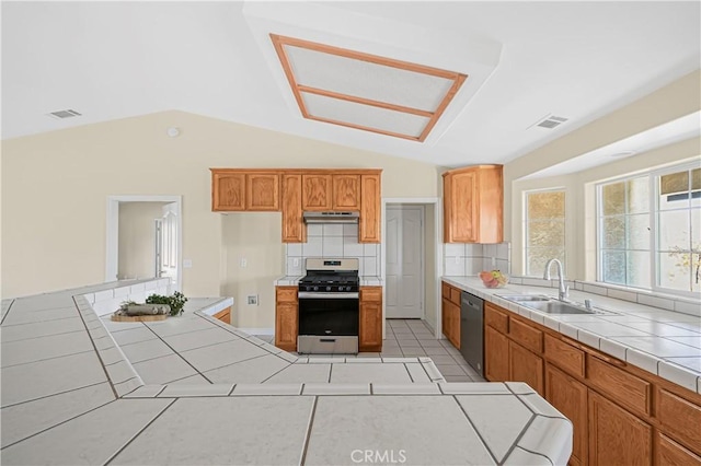 kitchen featuring visible vents, a sink, stainless steel appliances, tile counters, and tasteful backsplash