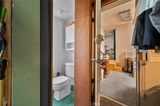 bathroom with toilet and a textured ceiling