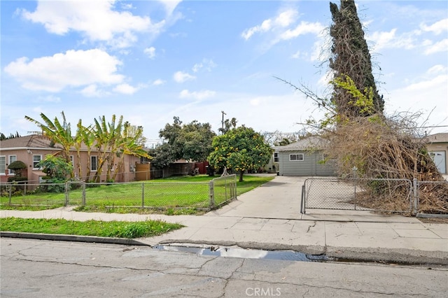 obstructed view of property featuring a front yard, concrete driveway, and a fenced front yard