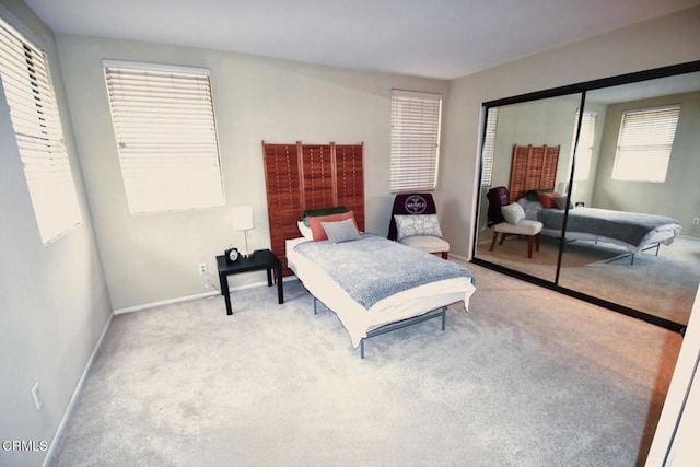 bedroom featuring a closet, baseboards, and carpet