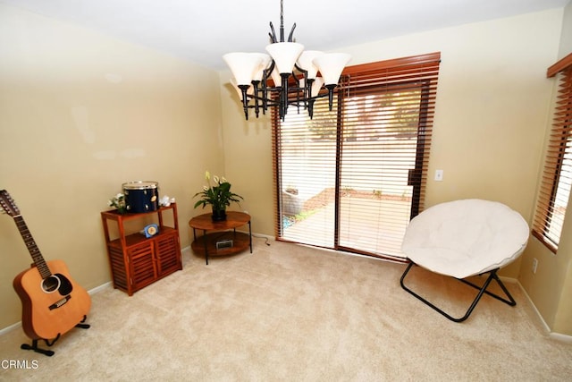 sitting room featuring a notable chandelier, baseboards, and carpet