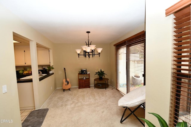 sitting room featuring light colored carpet, baseboards, and an inviting chandelier