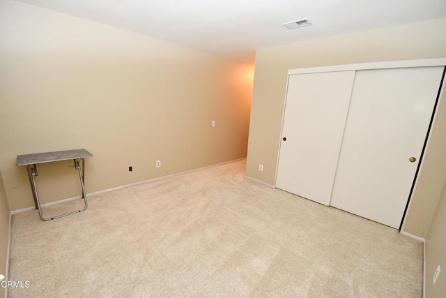 unfurnished bedroom featuring visible vents, carpet, a closet, and baseboards