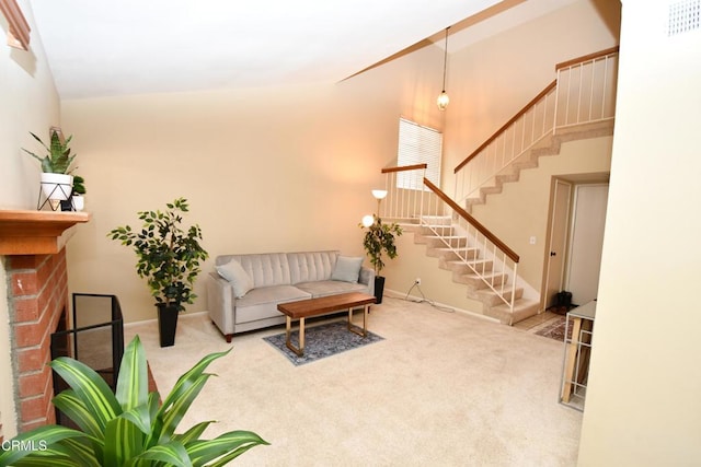 carpeted living area with visible vents, baseboards, stairway, a fireplace, and high vaulted ceiling