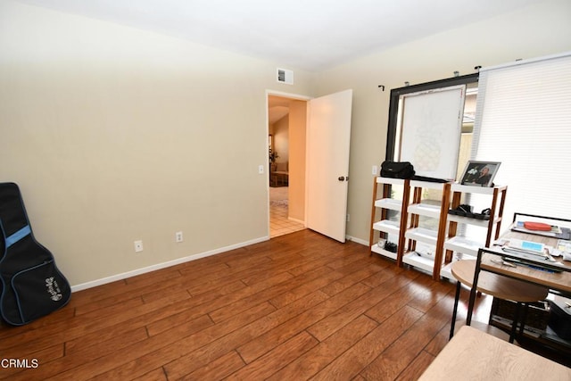 office space featuring visible vents, baseboards, and hardwood / wood-style floors