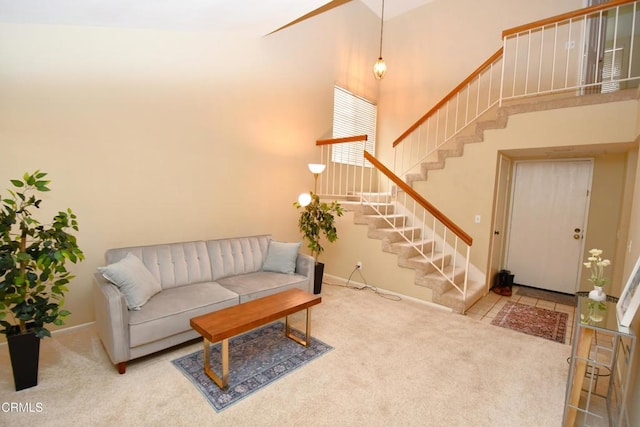 living area featuring baseboards, carpet floors, a high ceiling, and stairs