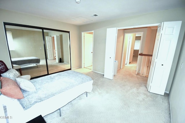 bedroom with carpet flooring, visible vents, and a closet