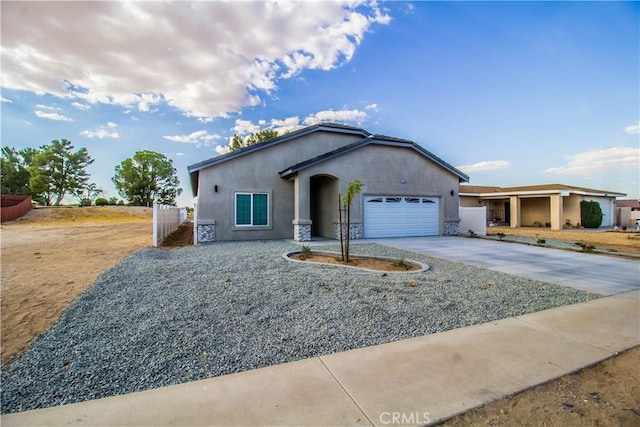 single story home with stucco siding, driveway, an attached garage, and fence