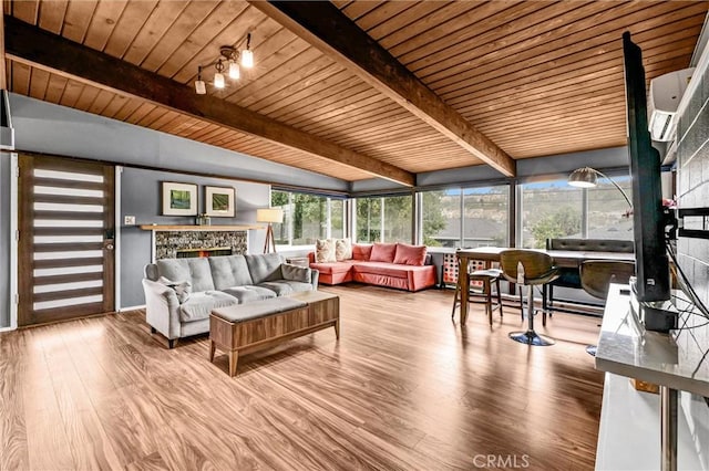 living room featuring lofted ceiling with beams, wooden ceiling, wood finished floors, and a fireplace