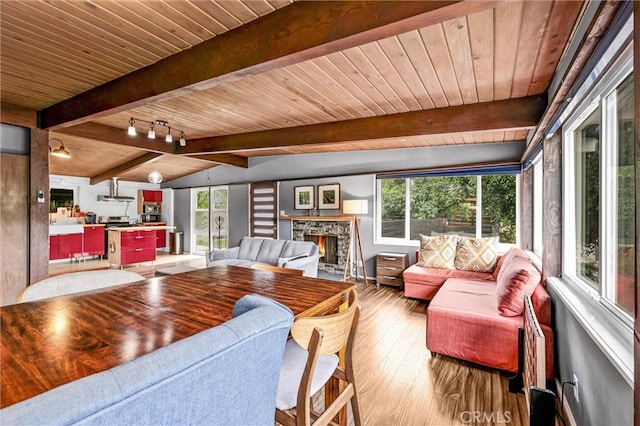 living area featuring wooden ceiling, vaulted ceiling with beams, wood finished floors, and a wealth of natural light