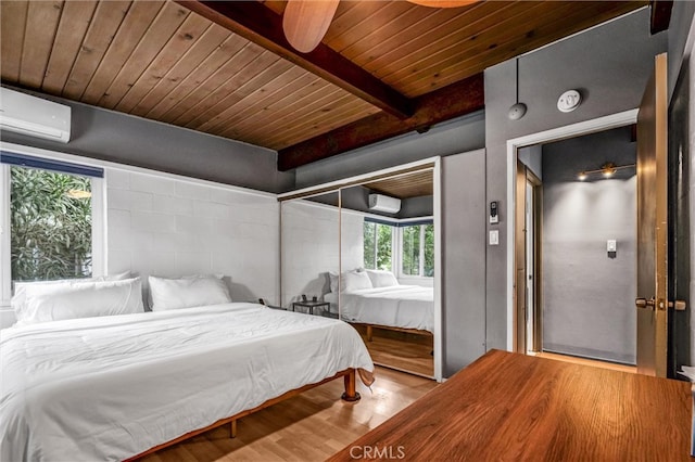 bedroom featuring beamed ceiling, wood finished floors, an AC wall unit, and wooden ceiling