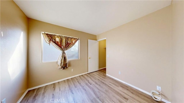 unfurnished room featuring baseboards and wood finished floors