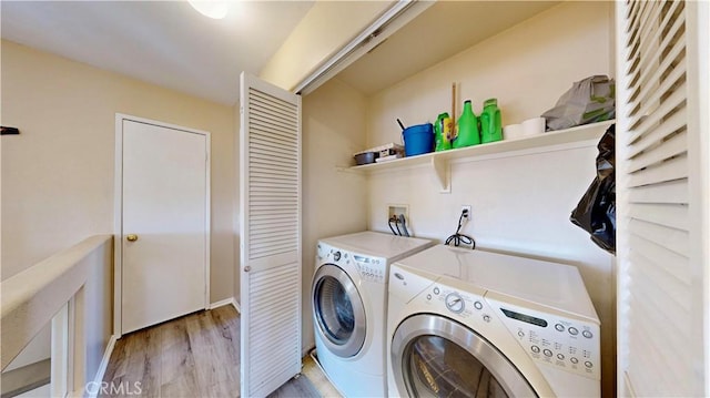 clothes washing area featuring laundry area, light wood-style flooring, and separate washer and dryer