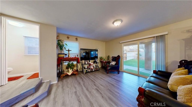 living area with baseboards and wood finished floors