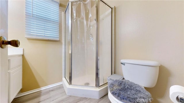 full bathroom featuring baseboards, toilet, wood finished floors, and a shower stall