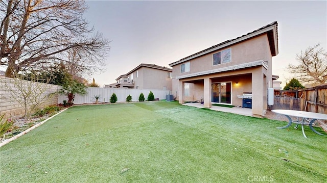 rear view of property with a patio area, stucco siding, cooling unit, and a fenced backyard