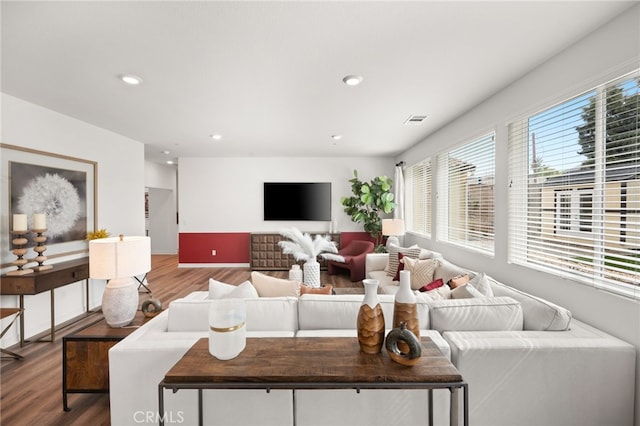 living area with recessed lighting, wood finished floors, and visible vents