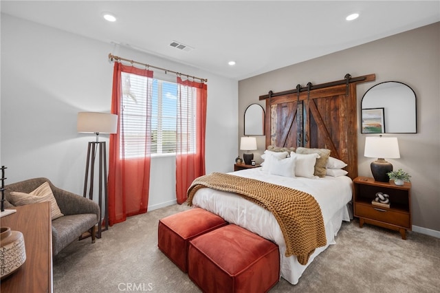 bedroom with a barn door, carpet flooring, and recessed lighting